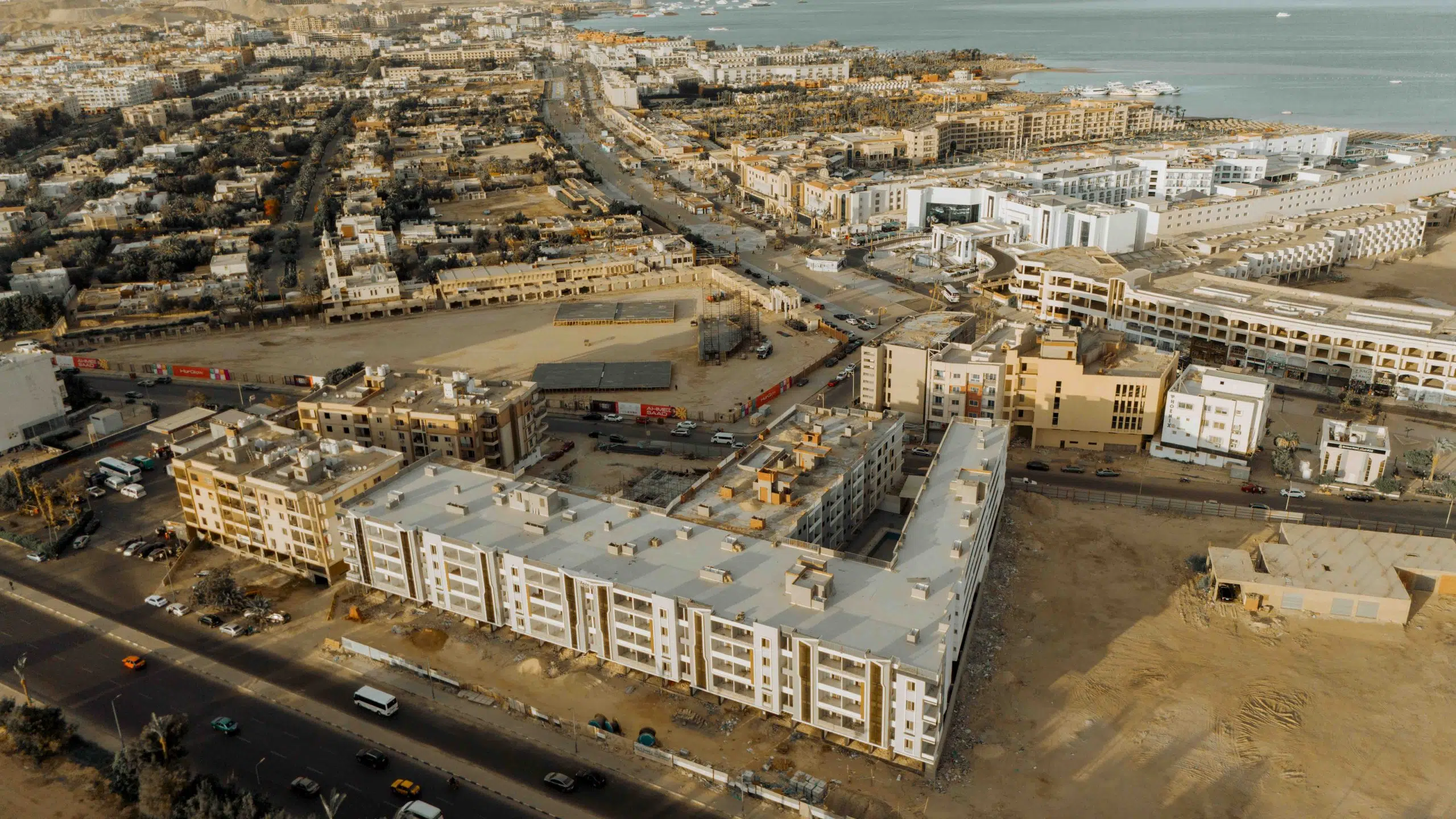 Waterfront Red Sea resort view with pools, beach access, and sea-facing residential buildings