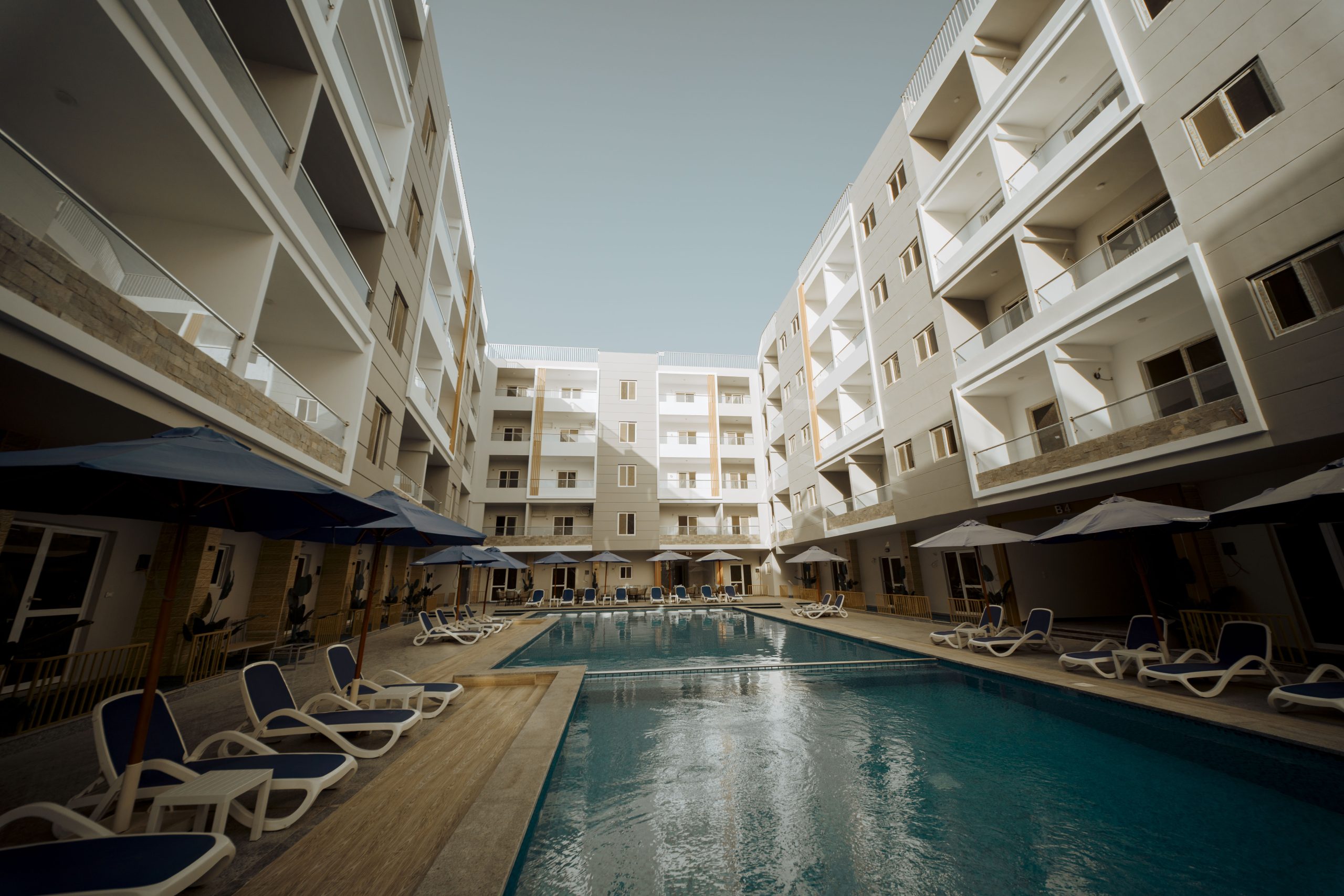 View along the Mark Resort courtyard swimming pool between apartment buildings