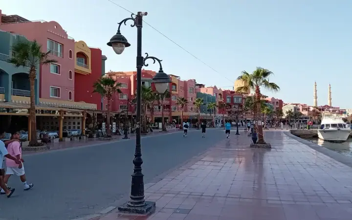 Pedestrians walking beside cafés on Hurghada Marina promenade