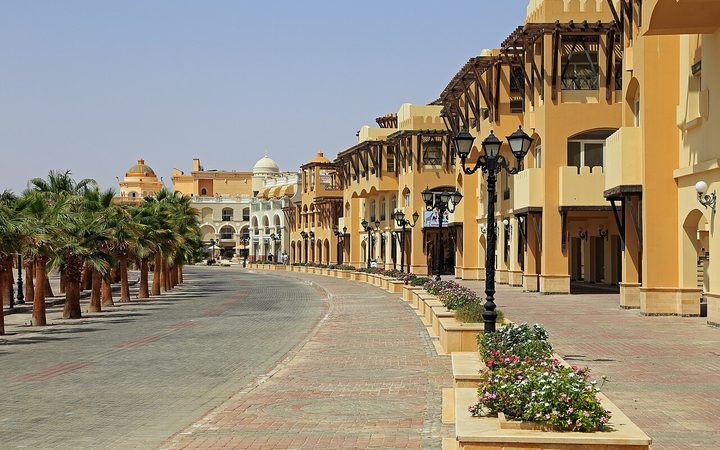 Palm-lined promenade beside Old Town buildings in Sahl Hasheesh